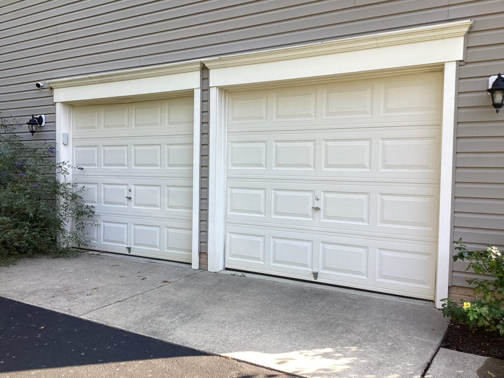 Matching white raised-panel garage doors at an A1 Door Company installation project